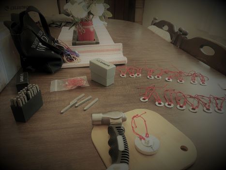table filled with tools and materials needed for hand-stamping jewelry