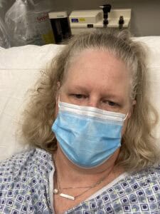 blonde female wearing blue face mask in hospital ER